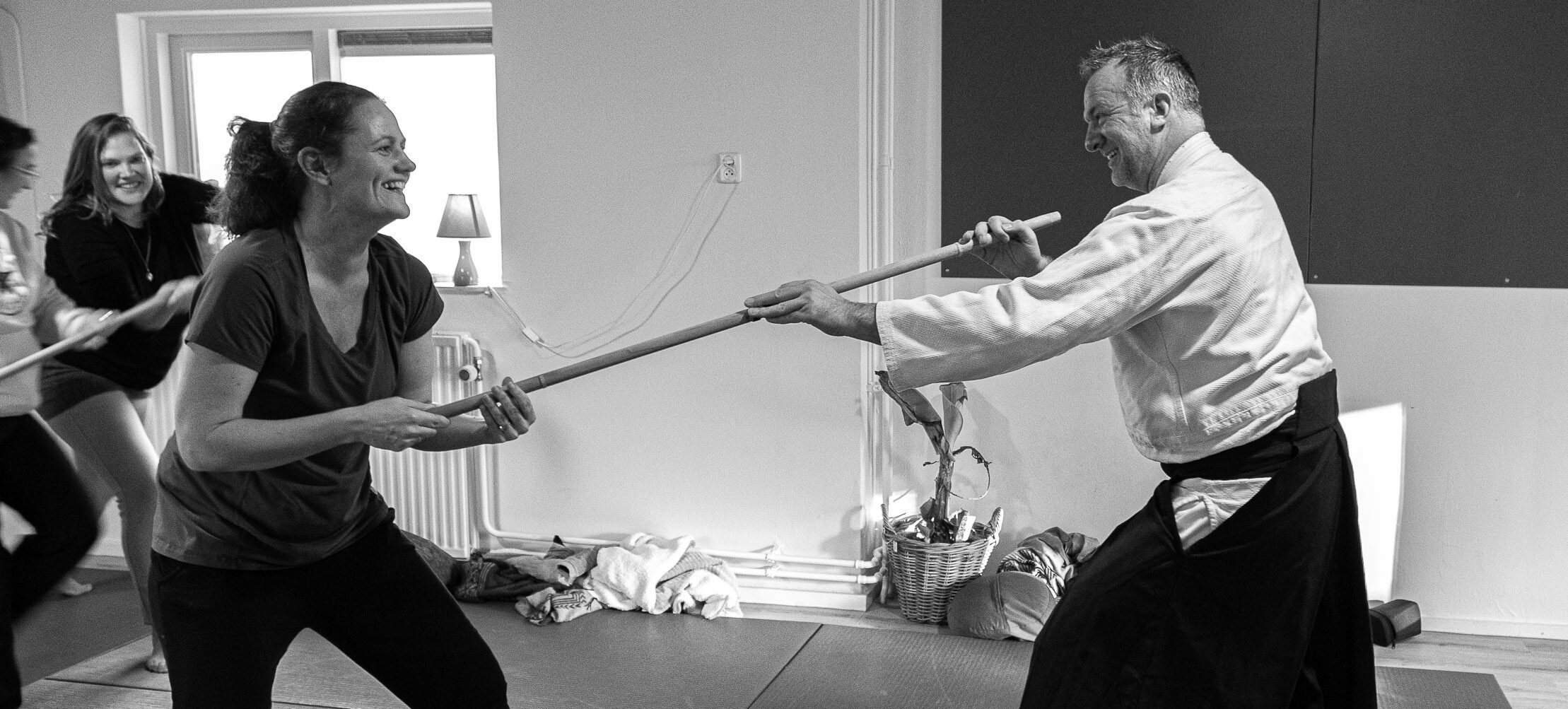 Richard Jacobsen oefent met een deelnemer met de jo, een houten staf, tijdens een training in de dojo